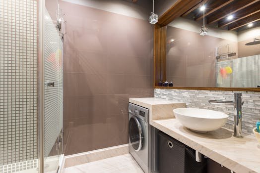 A contemporary bathroom featuring a washer, vessel sink, and stylish decor.